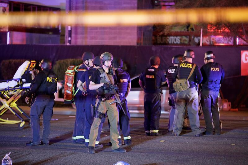 Police officers and medical personnel stand at the scene of a shooting near the Mandalay Bay resort and casino on the Las Vegas Strip. John Locher / AP Photo