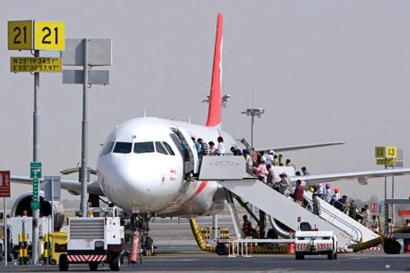 Sharjah - October 4, 2009 - Passengers board an Air Arabia jet on the tarmac at Sharjah International Airport in Sharjah, October, 4, 2009. (Photo by Jeff Topping/ The National) *** Local Caption ***  JT011-1004-AIR ARABIA_F8Q7131.jpg