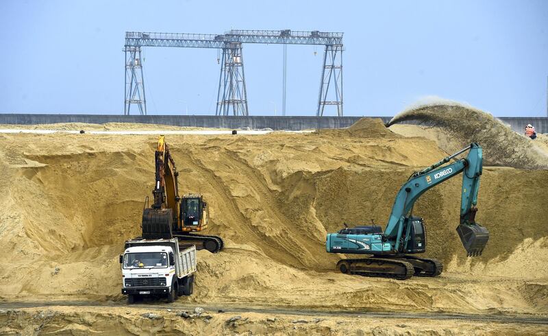 Lorries and cranes are seen in a construction site of a Chinese-funded 1.4 billion USD land reclamation project in Colombo on January 16, 2019. - A Chinese state-owned company marked on January 16 the completion of an ambitious $1.4 billion land reclamation in Sri Lanka's capital to build a new city next to the strategically-placed Colombo port. Sri Lanka's Megapolis Development Minister Patali Champika Ranawaka watched the final pumping of sand to create the 269-hectare (664 acre) real estate to build what is billed as South Asia's most modern city. (Photo by ISHARA S. KODIKARA / AFP)