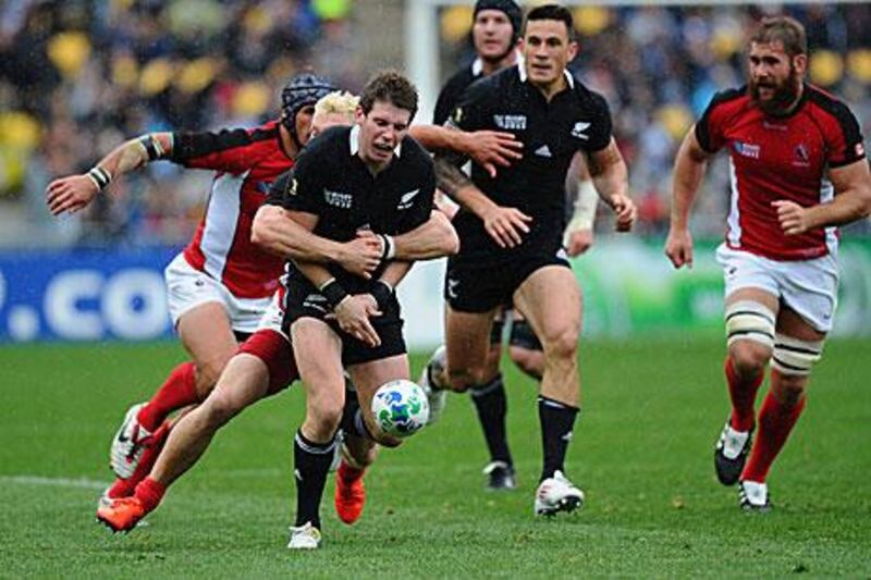 Colin Slade, the stand-in All Blacks fly-half, knocks on after a crushing tackle from Phil MacKenzie, the Canada centre, during his nervy performance in place of Dan Carter today.