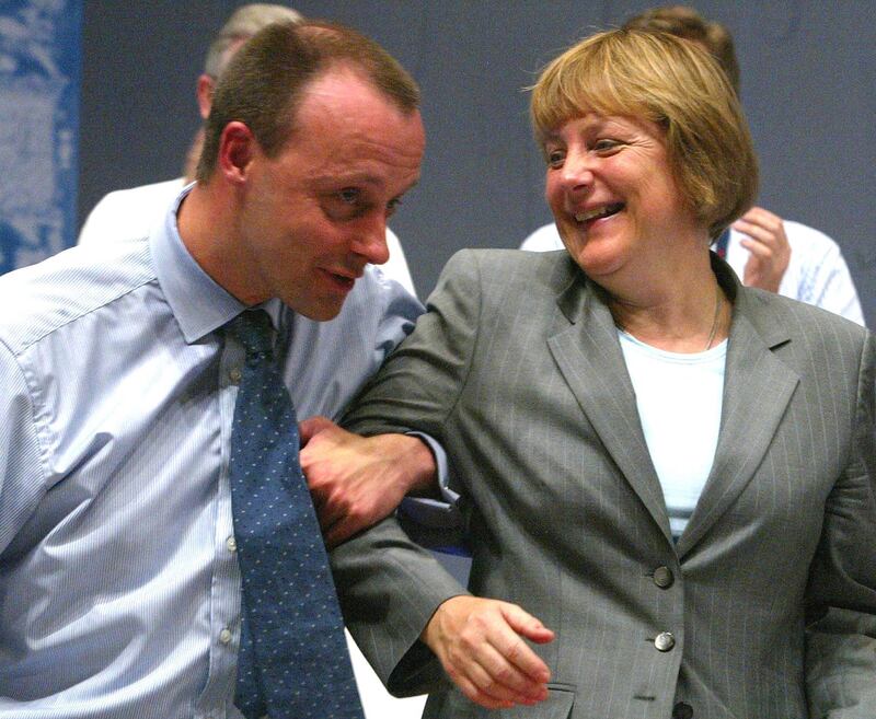 Friedrich Merz, parliamentary floor leader of the conservative German Christian Democratic Union party jokes with Angela Merkel after addressing the CDU party convention in Frankfurt, June 18, 2002. Reuters