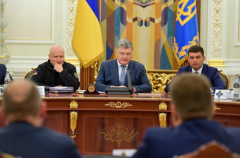 Ukrainian President Petro Poroshenko, center, leads the National Security and Defence Council meeting as Secretary of the National Security and Defense Council Oleksandr Turchynov, left, and Ukrainian Prime Minister Volodymyr Groysman listen to him, in Kiev, Ukraine, Wednesday, Dec. 26, 2018. Ukraine's leader has announced an end to the 30-day martial law imposed after Russia seized Ukrainian ships in the Black Sea.
(Mykola Lazarenko, Presidential Press Service via AP, Pool)