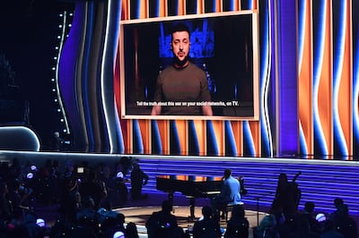 Ukraine's President Volodymyr Zelenskyy appears on screen, with John Legend sat on the piano on stage during the 64th Annual Grammy Awards at the MGM Grand Garden Arena in Las Vegas on April 3, 2022. AFP