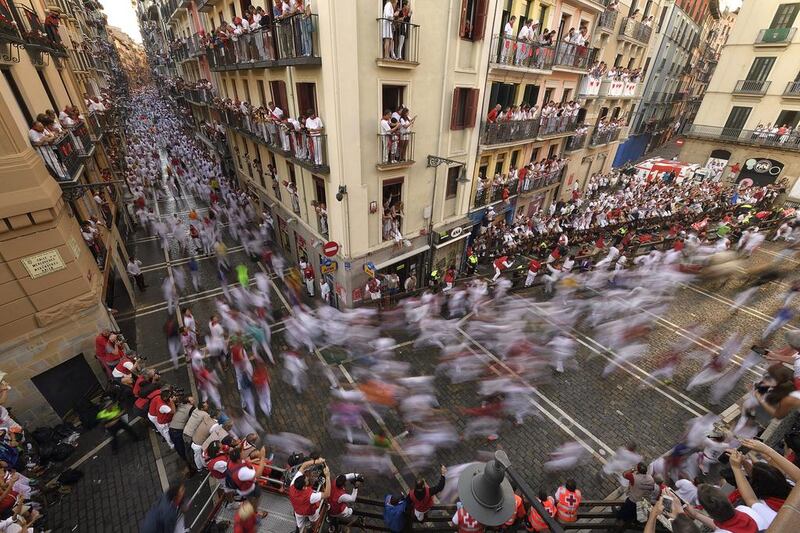 Revelers run beside Fuente Ymbro fighting bulls on the Estafeta corner during the first running of the bulls at the San Fermin Festival, in Pamplona, northern Spain, Thursday. Revelers from around the world arrive in Pamplona every year to take part in the running of the bulls. Alvaro Barrientos / AP