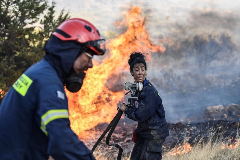 Firefighters work to put out a wildfire in Anavyssos, south of Athens, Greece. AFP