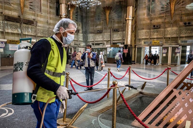 An Egyptian worker sprays disinfectant at Cairo's Ramses railway station. AFP