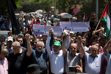 Head of the Hamas political bureau, Ismail Haniyeh, third from left, and Hamas leader in the Gaza Strip Yahya Sinwar raise their hands up with leaders of the other Palestinian factions as they attend a protest against the White House's long-awaited plan for Mideast peace, in Gaza City, Wednesday, June 26, 2019. AP