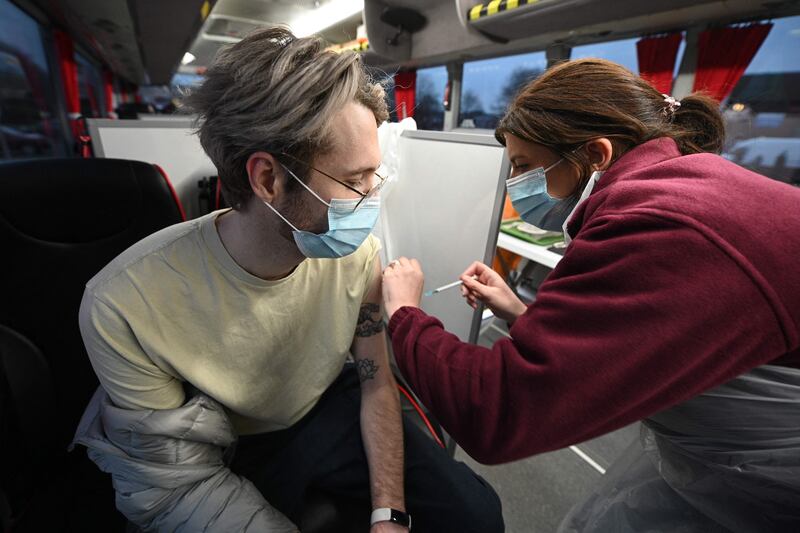 A man receives his Covid-19 vaccine inside a National Health Service bus in the town of Farnworth, near Manchester in north-west England. AFP