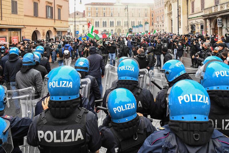 Police and protesters face one another on Piazza San Silvestro, central Rome, during a demonstration by restaurant owners and staff to demand financial aid and the easing of lockdown measures. AFP