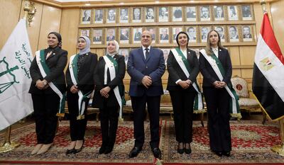 Taha Karsoi (C), secretary general of the State Council, welcomes some of the new Egyptian women judges in Giza. EPA