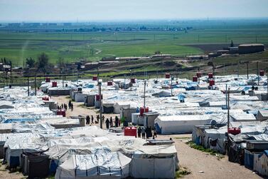 Women and children walk at Camp Roj, where relatives of people suspected of belonging to the Islamic State (IS) group are held, in the countryside near al-Malikiyah (Derik) in Syria's northeastern Hasakah province, on March 28, 2021. Roj, one of two Kurdish-run displacement camps housing foreign family members of suspected IS fighters, is smaller and better guarded than its overcrowded counterpart Al-Hol, which has been rocked by assassinations and breakout attempts in recent months. / AFP / Delil SOULEIMAN