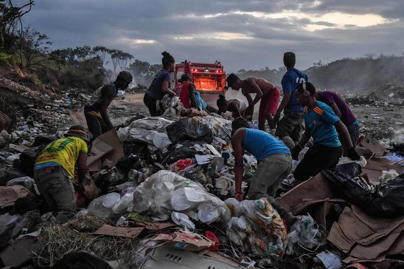 Venezuelan scavengers dig through trash at a landfill, in Pacaraima, Roraima State, Brazil. AFP
