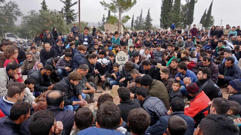 (FILES) In this file photo taken on November 23, 2018 Mourners attend the funeral of Raed Fares and Hammoud al-Jneid in the village of Kafranbel in the northwestern province of Idlib. Gunmen may have killed their most charismatic activist, but Syrians in Kafranbel are determined to keep the northwestern town's revolutionary spirit alive. The gunning down of Raed Fares on November 23 was the latest blow to what remains of the dwindling civil society movement that rose up against President Bashar al-Assad in 2011. / AFP / Muhammad HAJ KADOUR
