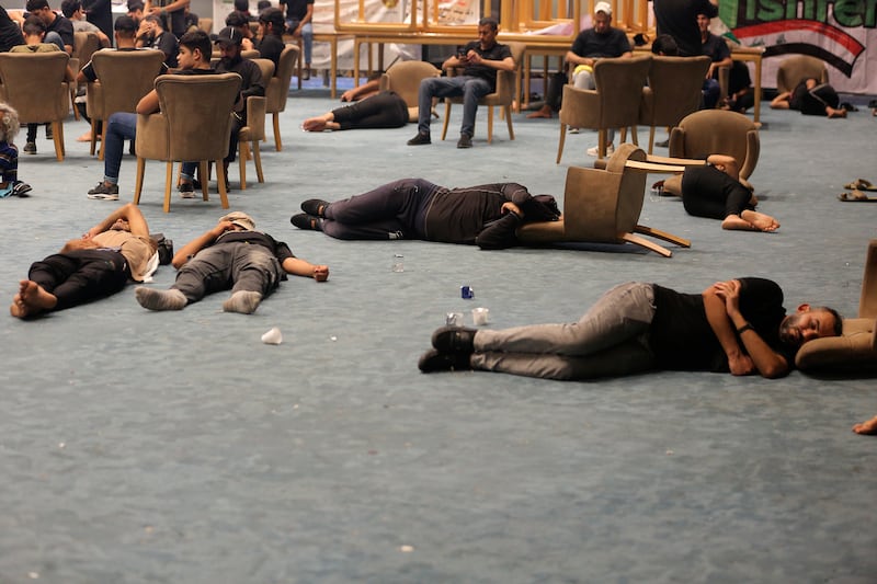 Mr Al Sadr's followers rest inside the parliament building during the protest. AP
