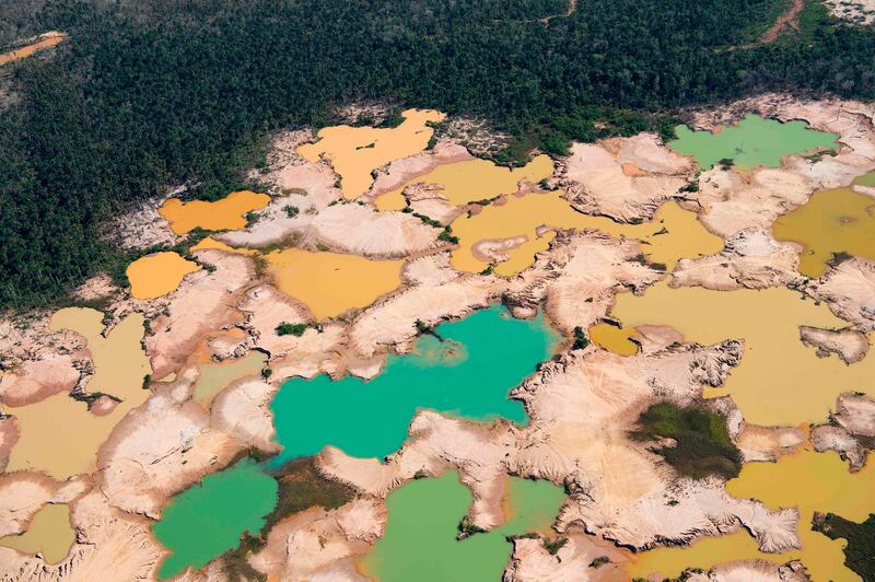 TOPSHOT - An aerial view over a chemically deforested area of the Amazon jungle caused by illegal mining activities in the river basin of the Madre de Dios region in southeast Peru, on May 17, 2019, during the 'Mercury' joint operation by Peruvian military and police ongoing since February 2019. Illegal mining activities for gold have caused irreversible ecological damage to more than 11,000 hectares of Amazonian forest and river basins, generating illicit activities in parallel such as human trafficking, mercury trafficking, hired killers and prostitution. / AFP / Cris BOURONCLE
