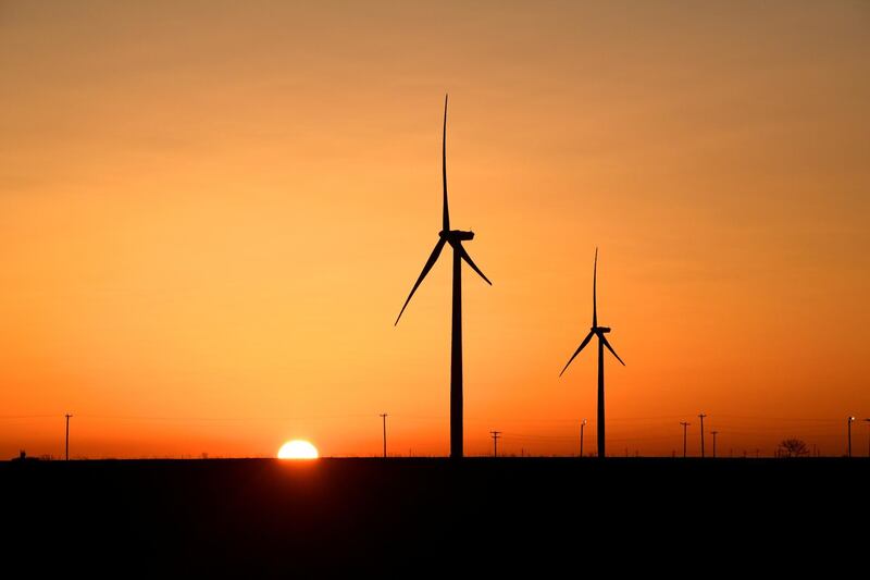 FILE PHOTO: Wind turbines operate at sunrise in the Permian Basin oil and natural gas production area in Big Spring, Texas, U.S., February 12, 2019. REUTERS/Nick Oxford/File Photo