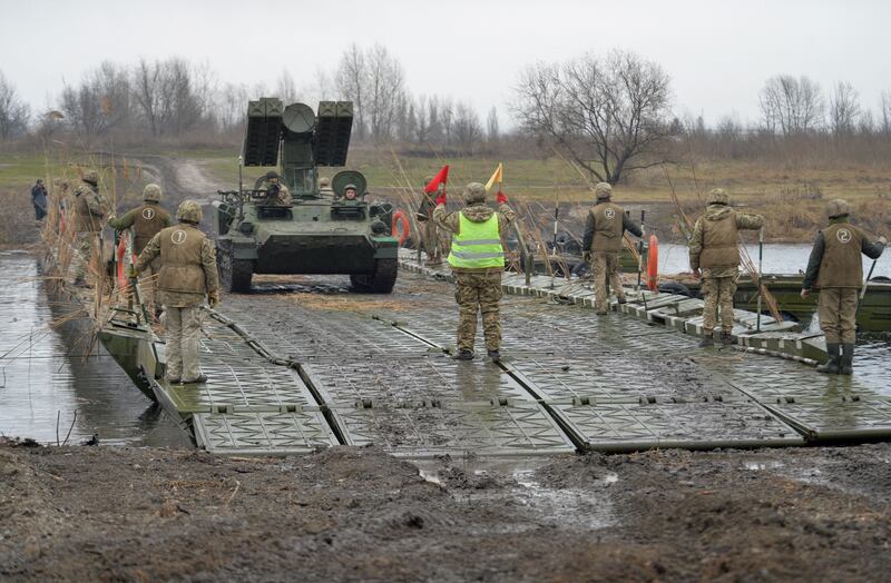 Ukrainian armed forces drive a self-propelled rocket launcher along a pontoon bridge while crossing the Aidar River during military drills near Novoaidar in the Luhansk region. Reuters