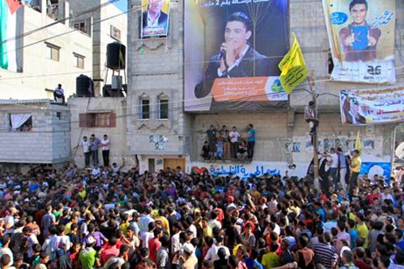 People wait for the arrival of Palestinian "Arab Idol" Mohammed Assaf in front his home in Khan Yunis town in the southern Gaza Strip June 25, 2013. Thousands of Gazans gave an ecstatic welcome to Mohammed Assaf as the 23-year-old Palestinian singer returned home after winning this year's Arab Idol talent competition. AFP PHOTO/SAID KHATIB