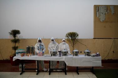 Hospital staff wearing personal protective equipment wait for coronavirus patients during an evening buffet on the outskirts of New Delhi, on September 15, 2020. Reuters