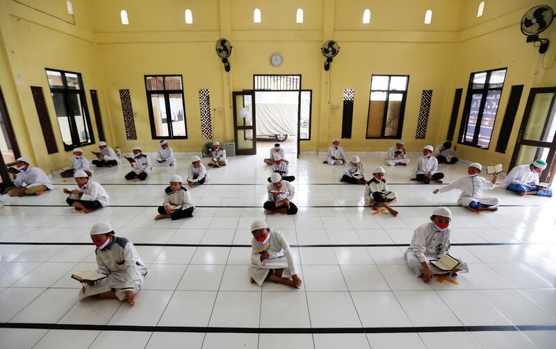 Muslim students wearing face masks practice social distancing while reading the Quran  in Indonesia. Reuters
