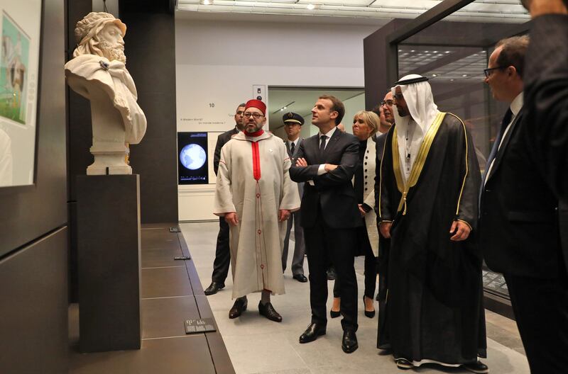 King Mohammed VI of Morocco, French President Emmanuel Macron, his wife Brigitte and  Director General of Abu Dhabi's Tourism and Culture Authority Saif Saeed Ghobash look at a piece of art. Ludovic Marin / AFP Photo
