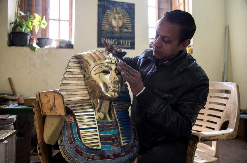 An artist gives final touch on a replica of King Tut mask at the Replica Production Unit located at Salah Al Din Citadel in Cairo, Egypt. EPA