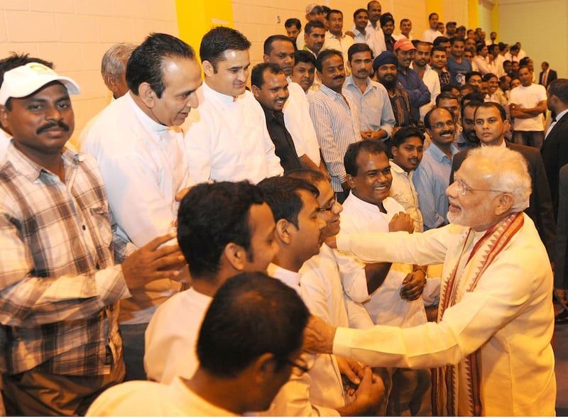 Mr Modi greets a group of Indian workers living in Abu Dhabi. Wam