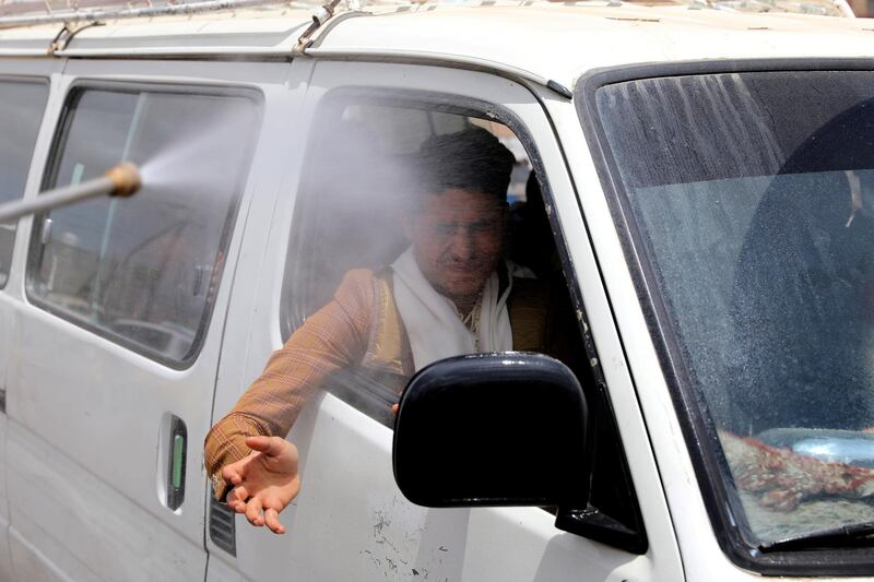 A health worker sprays disinfectant on a man in a van on the outskirts of Sanaa, Yemen. Reuters