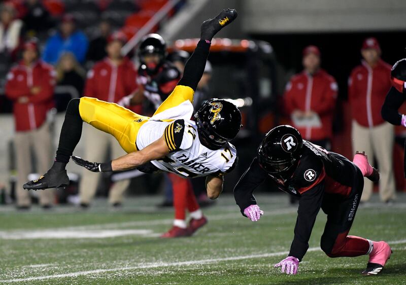 Hamilton Tiger-Cats wide receiver Luke Tasker gets upended by Ottawa Redblacks defensive back Antoine Pruneau during first-half CFL football game action in Ontario. Justin Tang / The Canadian Press via AP