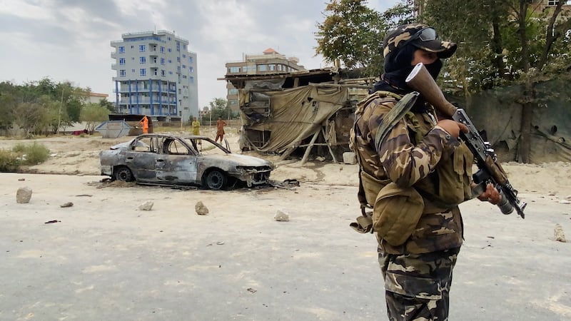 A Taliban member stands guard near a vehicle which was used to fire rockets at the Hamid Karzai International Airport in Kabul on August 30, 2021. EPA