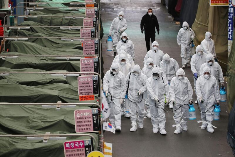 TOPSHOT - Market workers wearing protective gear spray disinfectant at a market in the southeastern city of Daegu on February 23, 2020 as a preventive measure after the COVID-19 coronavirus outbreak. South Korea reported two additional deaths from coronavirus and 123 more cases on February 23, with nearly two thirds of the new patients connected to a religious sect. The national toll of 556 cases is now the second-highest outside of China. -  - South Korea OUT / REPUBLIC OF KOREA OUT  NO ARCHIVES  RESTRICTED TO SUBSCRIPTION USE    
 / AFP / YONHAP / - / REPUBLIC OF KOREA OUT  NO ARCHIVES  RESTRICTED TO SUBSCRIPTION USE    
