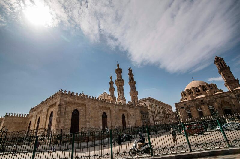 A few people walk in the vicinity of the closed Al-Azhar mosque in Egypt's capital Cairo on March 20, 2020, after the country's Muslim religious authorities decided to put the Friday prayers on hold, in order to avoid gatherings and the spread of the novel coronavirus COVID-19 disease.  / AFP / Khaled DESOUKI
