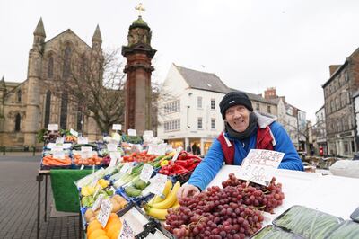 Fruit and vegetable seller Billy Atkinson, 59, outside the abbey in Hexham, Northumberland, which was named as Britain's happiest place to live in 2021. PA