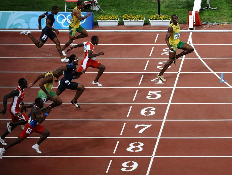 (FILES) This file photo taken on August 16, 2008 shows Jamaica's Usain Bolt (R) crossing the finish line to win the men's 100m final at the National stadium as part of the 2008 Beijing Olympic Games. Sprint legend Usain Bolt stayed ahead of the field for coronavirus tweets when he posted a photo on April 13, 2020 captioned "social distancing" showing him crossing the finish line ahead of his competitors at the 2008 Beijing Olympics. / AFP / Nicolas ASFOURI
