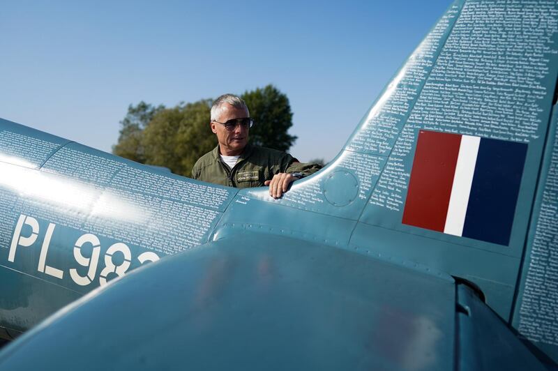 DARLINGTON, ENGLAND - SEPTEMBER 22: Pilot John Romain stands with his NHS Spitfire aircraft after landing at Durham Tees Valley airport as part of a charity flypast on September 22, 2020 in Darlington, England. The blue Spitfire PL983 nicknamed ‚ÄòL‚Äô was specifically built and used for photo reconnaissance during World War Two and carried cameras instead of weapons. Now the aircraft, owned by the Aircraft Restoration Company is branded with ‚ÄôThank U NHS‚Äô on the underside. After taking off from its home base at Duxford Airfield in Cambridgeshire its flight path takes it over hospitals and local communities around the country. Its journey aims to raise funds for NHS Charities Together and members of the public have had the opportunity to nominate anyone who has carried out an act of kindness during the coronavirus pandemic and in return for a donation have their names hand-written onto the Aircraft‚Äôs fuselage. (Photo by Ian Forsyth/Getty Images)