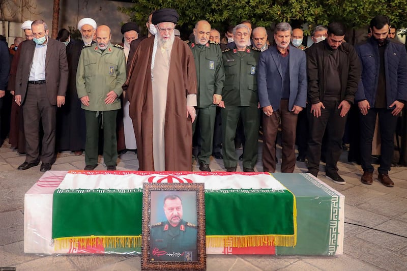 A handout picture provided by the office of Iran's Supreme Leader Ayatollah Ali Khamenei on December 28, 2023, shows him praying next to the coffin of of Razi Moussavi, a senior commander in the Quds Force of Iran's Islamic Revolutionary Guard Corps (IRGC) who was killed on December 25 in an Israeli strike in Syria, in Tehran.  (Photo by KHAMENEI. IR / AFP) / === RESTRICTED TO EDITORIAL USE - MANDATORY CREDIT "AFP PHOTO / HO / KHAMENEI. IR" - NO MARKETING NO ADVERTISING CAMPAIGNS - DISTRIBUTED AS A SERVICE TO CLIENTS ===