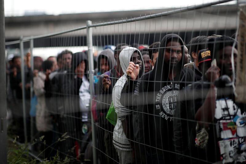 Migrants with their belongings stand in line as French police evacuate hundreds of migrants living in makeshift camps in Paris, France. Benoit Tessier / Reuters