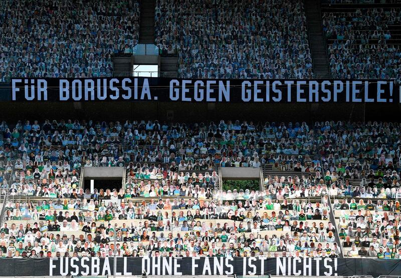Cardboards with photos of Moenchengladbach fans are seen on the stands prior to the . The banners on the stands read: "For Borussia. Against ghost games!" AFP