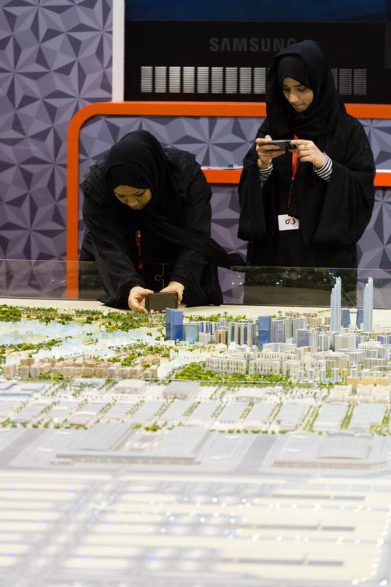 Visitors look at a model of Dubai World Central's Al Maktoum International Airport on display at the airport show. Duncan Chard for the National.