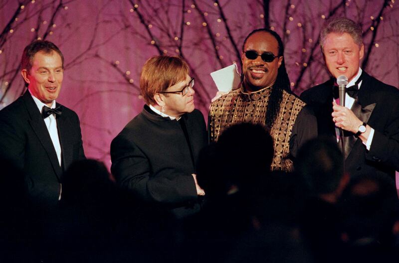 Former British prime minister Tony Blair, left, with US President Bill Clinton, right, thanking Elton John and Stevie Wonder after the duo performed at the White House State Dinner on, February 5, 1998. PA