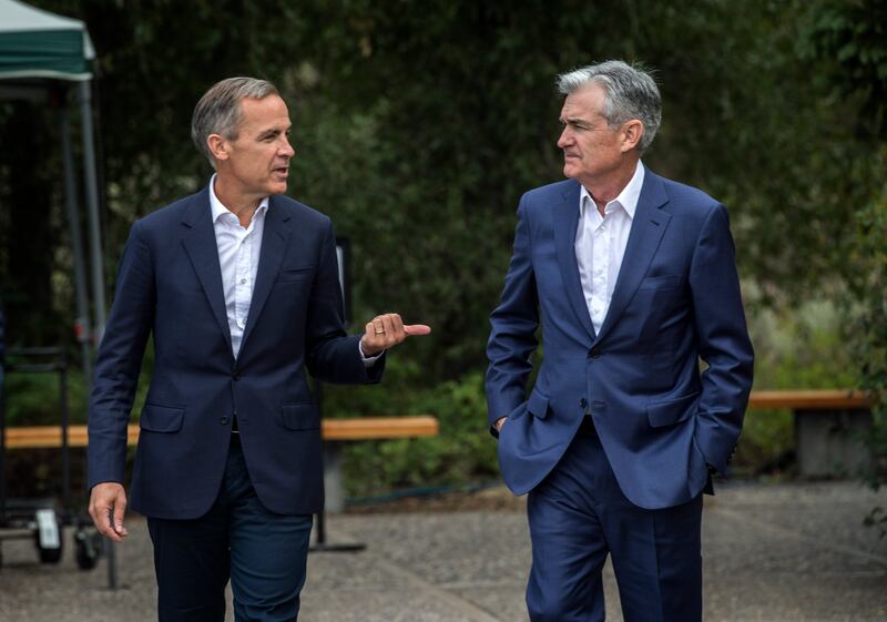 Bank of England Governor Mark Carney, left, and Jerome Powell, Chairman of the Board of Governors of the Federal Reserve System, right, chat after Powell's speech at the Jackson Hole Economic Policy Symposium on Friday, Aug. 23, 2019, in Jackson Hole, Wyo. (AP Photo/Amber Baesler)
