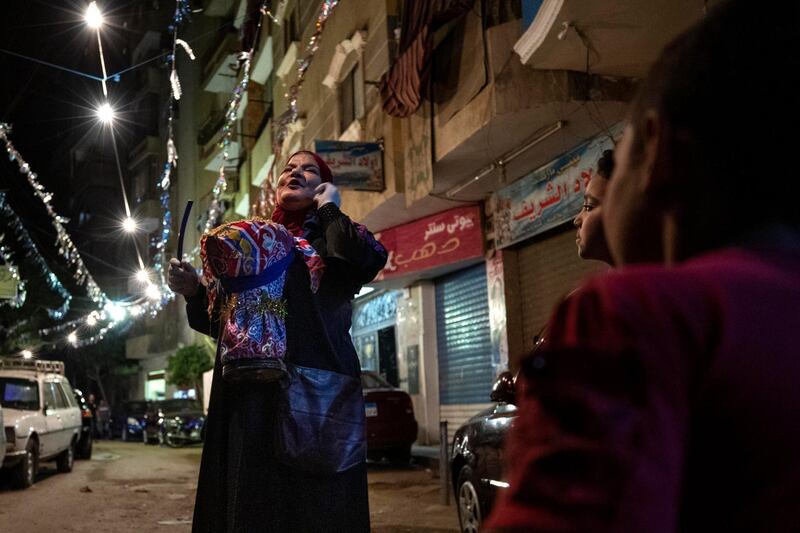 Hajja Dalal, a 46-year-old "mesaharati," or dawn caller, wakes people up for a meal before sunrise in Cairo. AP