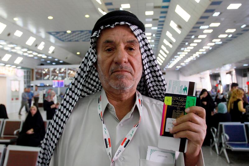 An Iraqi pilgrim shows his passport and ticket to Mecca as he wait for his flight at the airport in Najaf on July 31, 2018, prior to the start of the annual Hajj pilgrimage in the holy city of Makkah. AFP / Haidar Hamdani