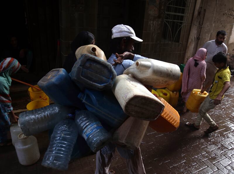 A man carries jerrycans to be filled with water in Karachi, Pakistan. EPA