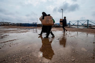 Children carrying humanitarian aid packages in Al Hol camp, north-eastern Syria. Delil Souleiman / AFP