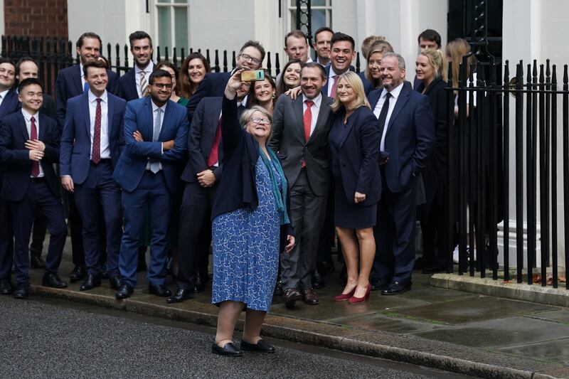 Deputy Prime Minister Therese Coffey takes a selfie while waiting for Mr Truss to make a speech outside 10 Downing Street. PA