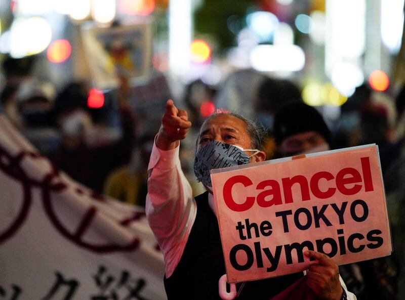 An anti-Olympics group member gestures as he holds a sign during a protest march, amid the coronavirus disease (COVID-19) outbreak, in Tokyo, Japan May 17, 2021. REUTERS/Naoki Ogura