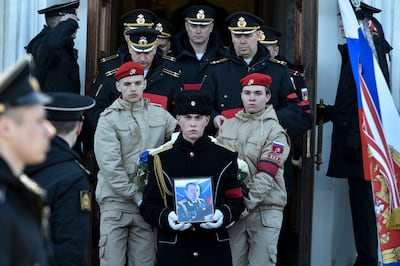 A serviceman carries the photo of Capt Andrei Paliy, a deputy commander of Russia's Black Sea Fleet, during a farewell ceremony in Sevastopol, Crimea. Paliy was killed in action during the fighting with Ukrainian forces in the Sea of Azov port, Mariupol. Photo: AP
