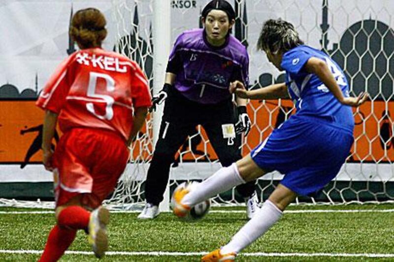 Japan's Nao Kobayashi lines up a shot against the International Golden Group's Moroccan goalkeeper, Elham Hemodi.