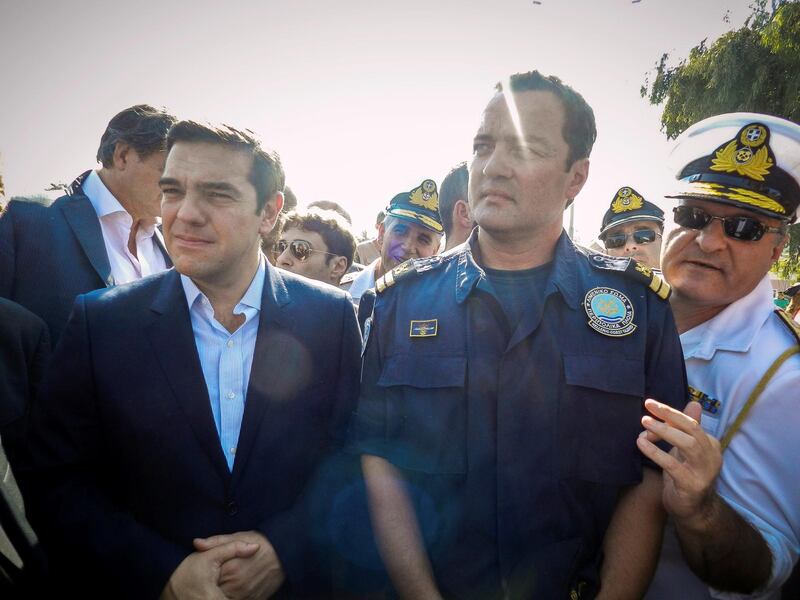 Greek Coast Guard Lieutenant Kyriakos Papadopoulos stands next to Greek Prime Minister Alexis Tsipras during Tsipras's visit to the island of Lesbos, Greece October 6, 2015. Picture taken October 6, 2015. Eurokinissi via REUTERS ATTENTION EDITORS - THIS IMAGE WAS PROVIDED BY A THIRD PARTY. NO RESALES. NO ARCHIVE. GREECE OUT.